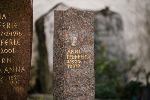 Schlanke polierte Granit-Stele in Rot neben bestehendem Familiengrabstein auf historischem Friedhof