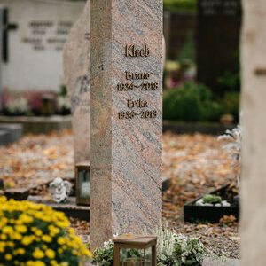 Hohe polierte Granit-Stele mit farbiger Maserung in Rosa und Grau sowie Bronzeschrift von STOI