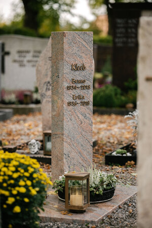 Hohe polierte Granit-Stele mit farbiger Maserung in Rosa und Grau sowie Bronzeschrift von STOI