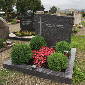 Polierter Blaugranit-Grabstein mit Kreuz-Gravur und charakteristischen Farbwirbeln von STOI