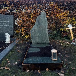 Natürlicher Fels-Grabstein aus dunkelgrünem Naturstein mit umrahmender Corten-Stahl Einfassung