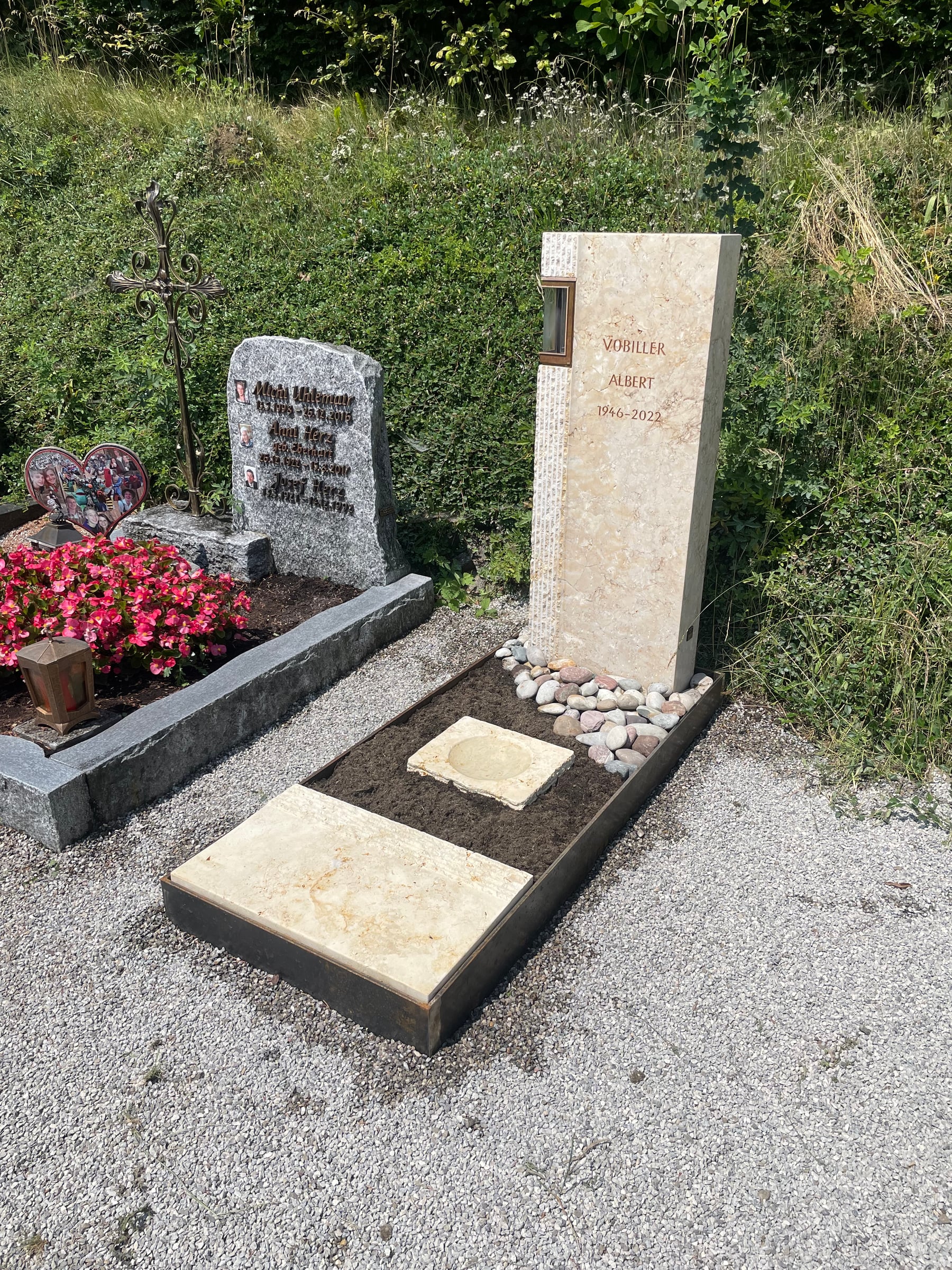 Cremweiße Kalkstein-Stele mit gestockter Oberfläche und seitlich integrierter beleuchteter Laterne