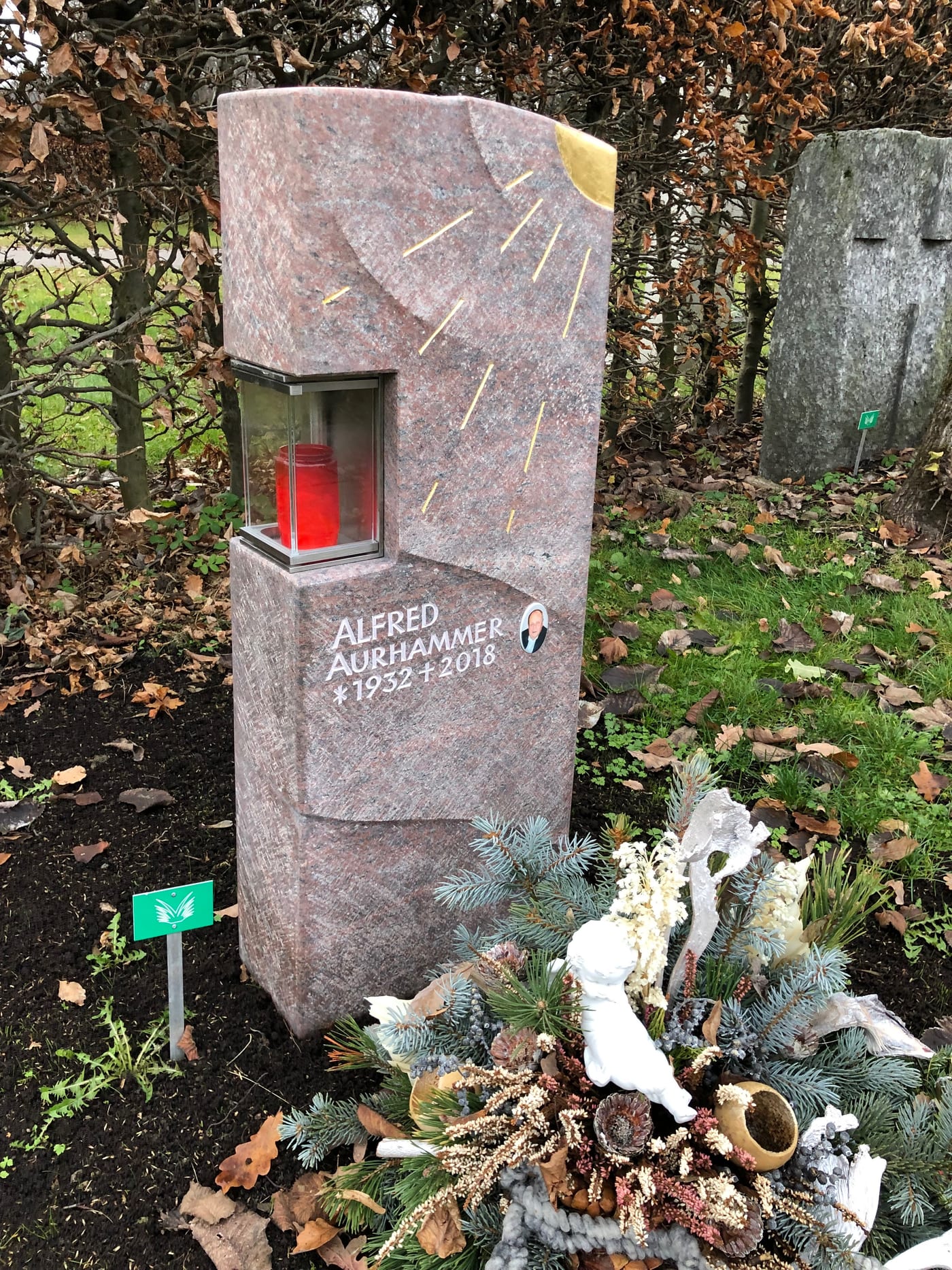 Warmroter Granit-Grabstein mit sandgestrahltem Sonnenmotiv, integrierter Kerze und Porträtmedaillon – Ansicht 2