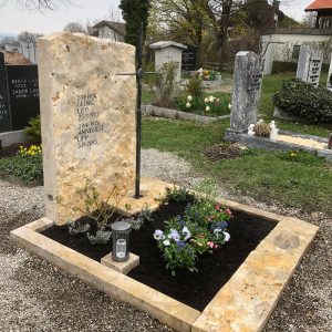 Großer Jura-Kalkstein Doppelgrabstein mit schlankem Metallkreuz auf dem Friedhof – STOI Steinmetzwerkstatt
