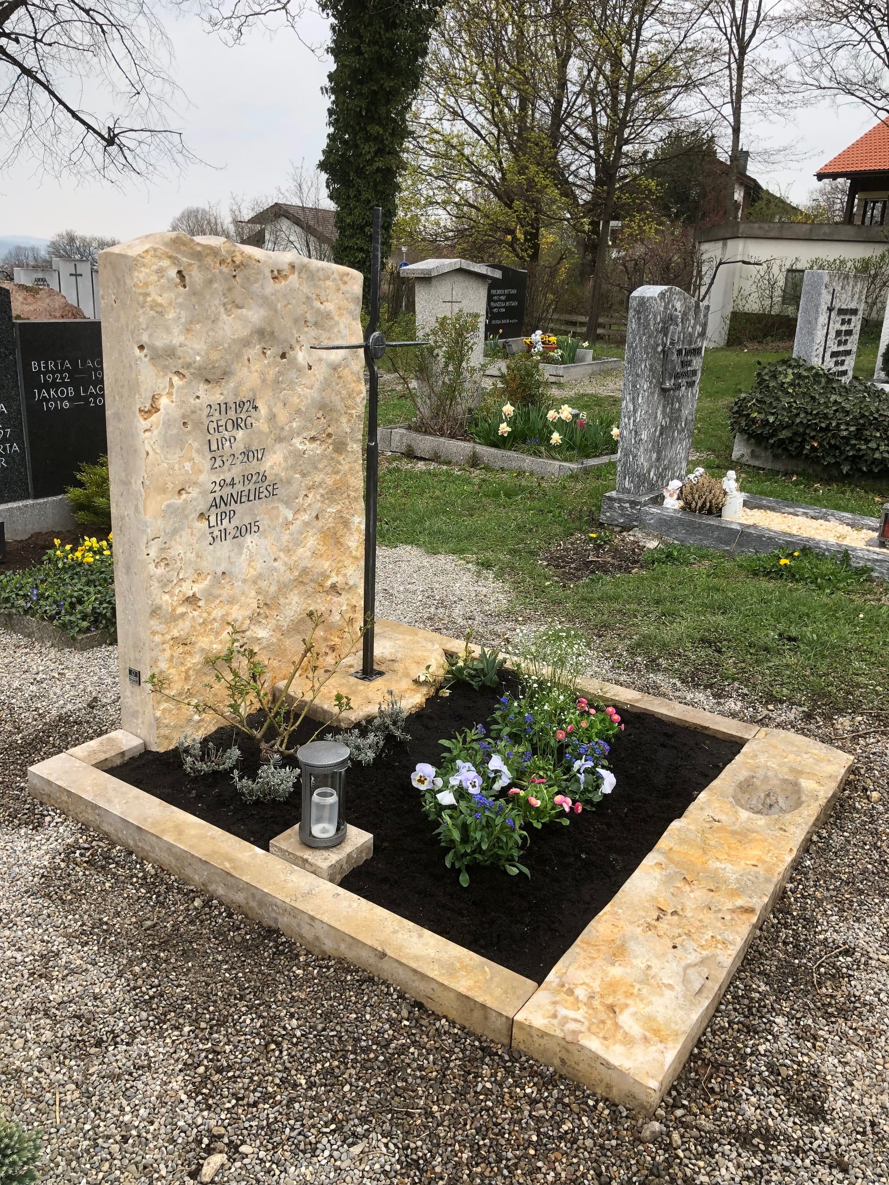 Großer Jura-Kalkstein Doppelgrabstein mit schlankem Metallkreuz auf dem Friedhof – STOI Steinmetzwerkstatt