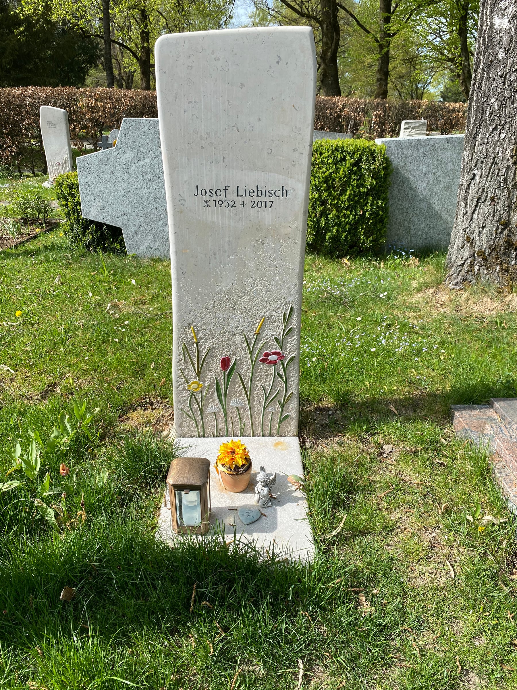 Heller Kalkstein-Grabstein mit handgemeißeltem Blumenrelief aus Tulpen und Stängeln mit Farbakzenten