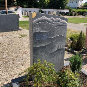 Flacher Granit-Liegestein mit handgraviertem Bergpanorama, Tannen und Gipfeln, STOI Steinmetzwerkstatt