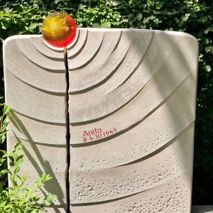 Heller Naturstein-Grabstein mit Stockwerkoberfläche, Kreisrillung und bernsteinfarbener Glaskugel als Sonnen-Motiv