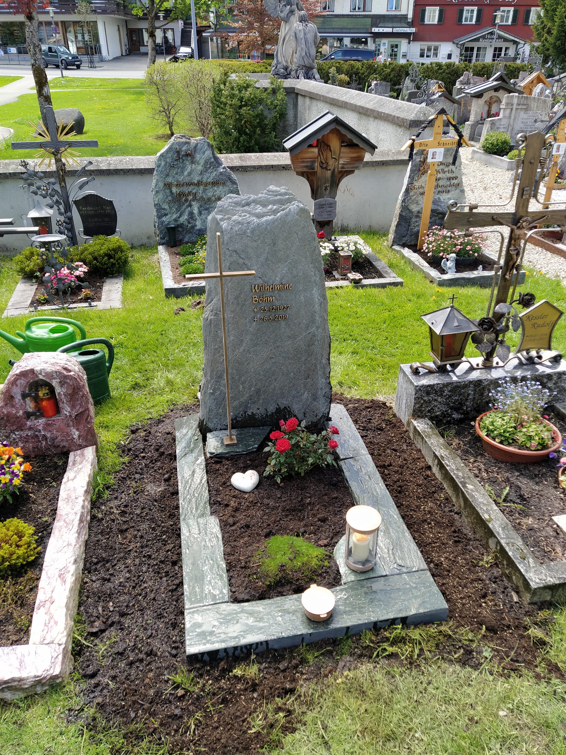 Naturbelassener dunkelgrüner Diabas-Felsstein mit Goldkreuz auf dem Friedhof – STOI Steinmetzwerkstatt