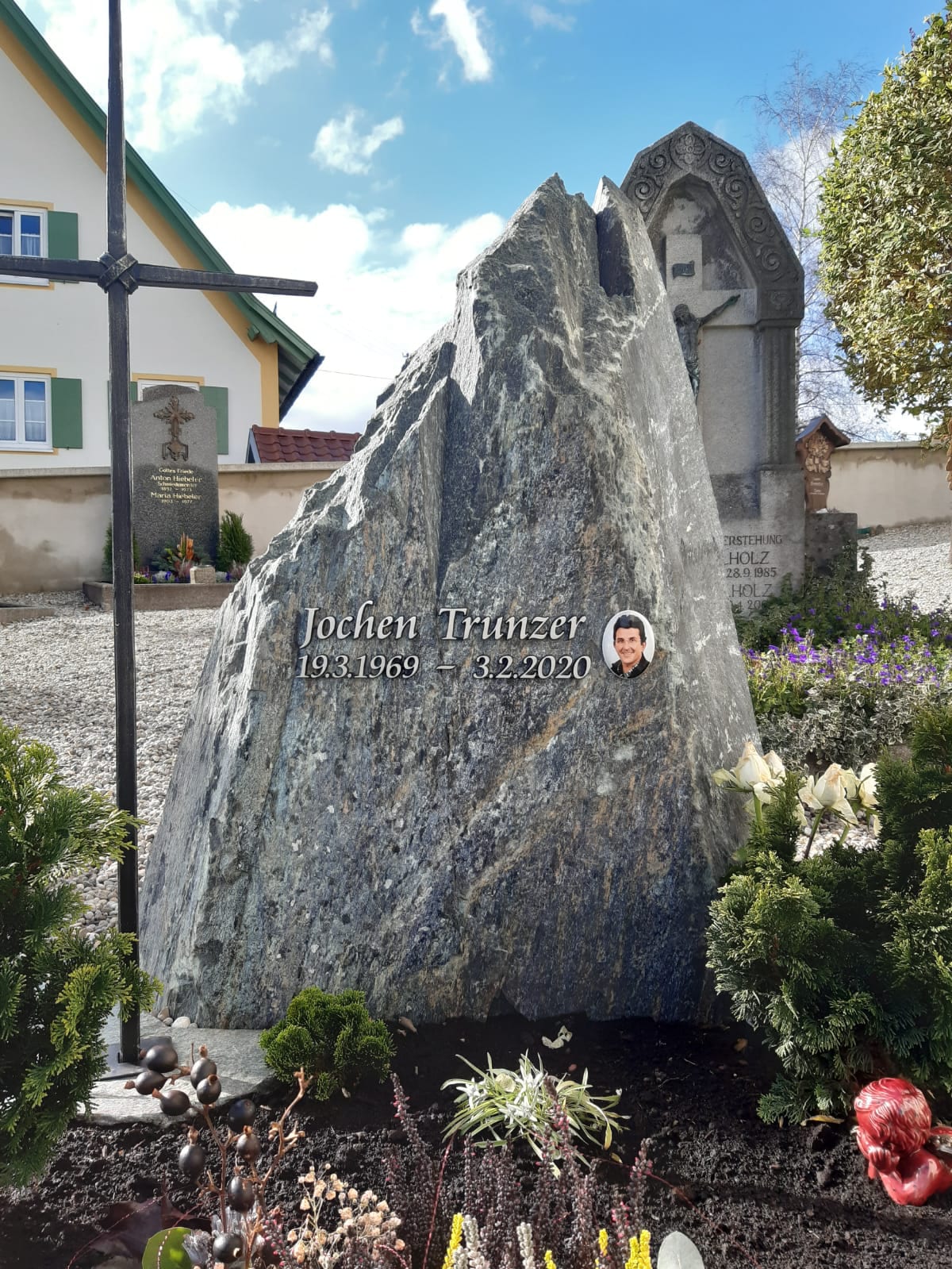 Naturbelassener Granit-Felsen als Grabstein mit polierter Inschrift und Keramik-Porträtfoto von STOI