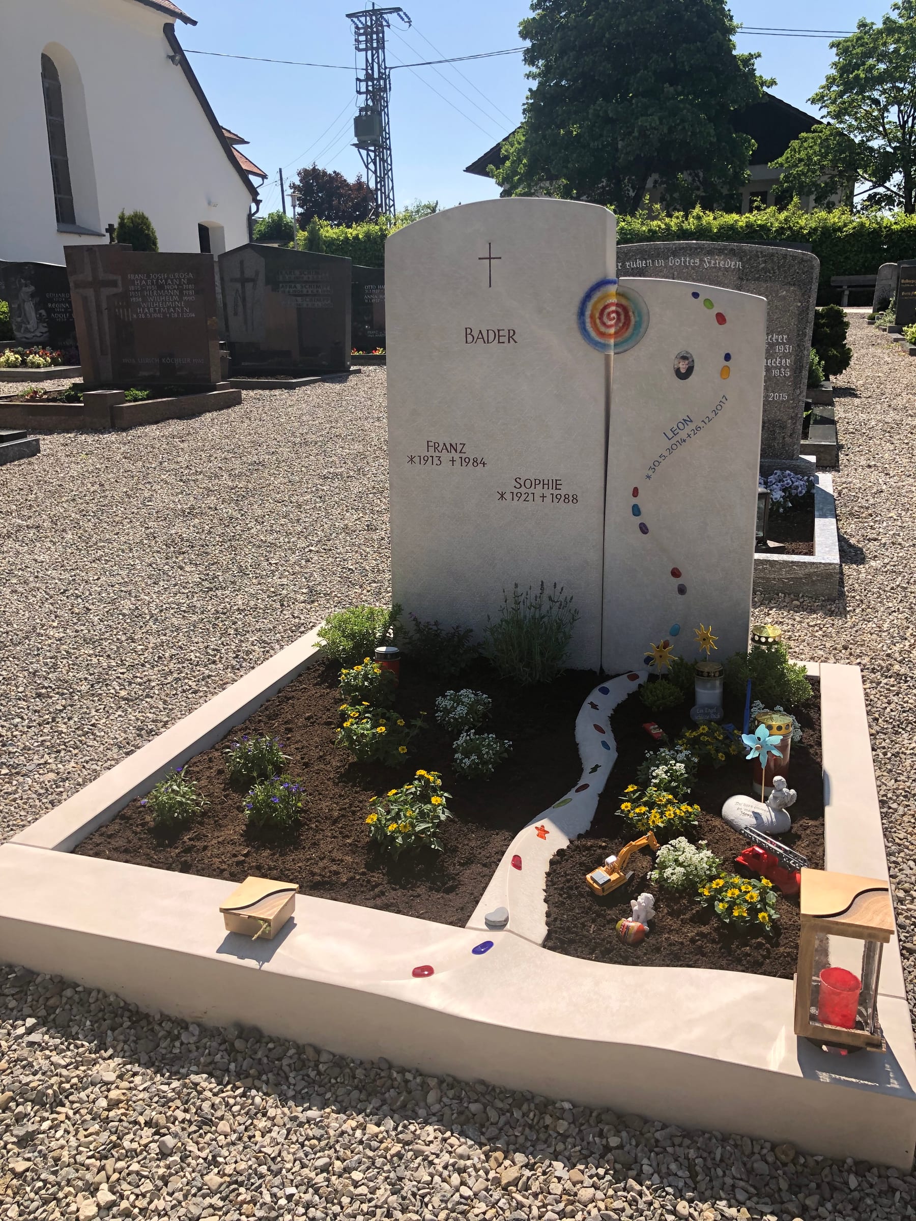 Zweiteiliger Kindergrabstein aus Granit mit farbigen Glasmosaik-Einlagen und organischen Stele-Formen