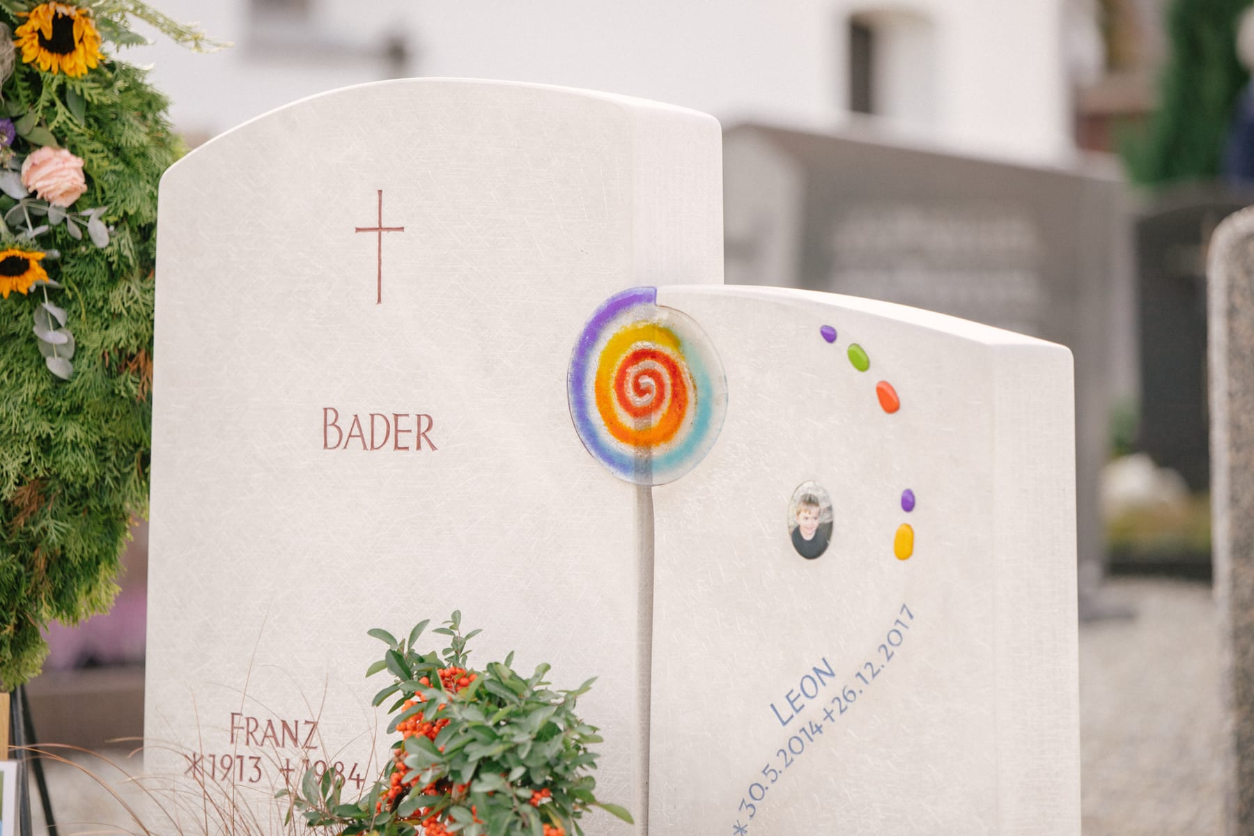 Zweiteiliger Kindergrabstein aus Granit mit farbigen Glasmosaik-Einlagen und organischen Stele-Formen