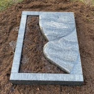 Hellgrauer Granit-Liegestein für Urnengrab mit poliertem Doppelherz-Motiv und Schriftgravur