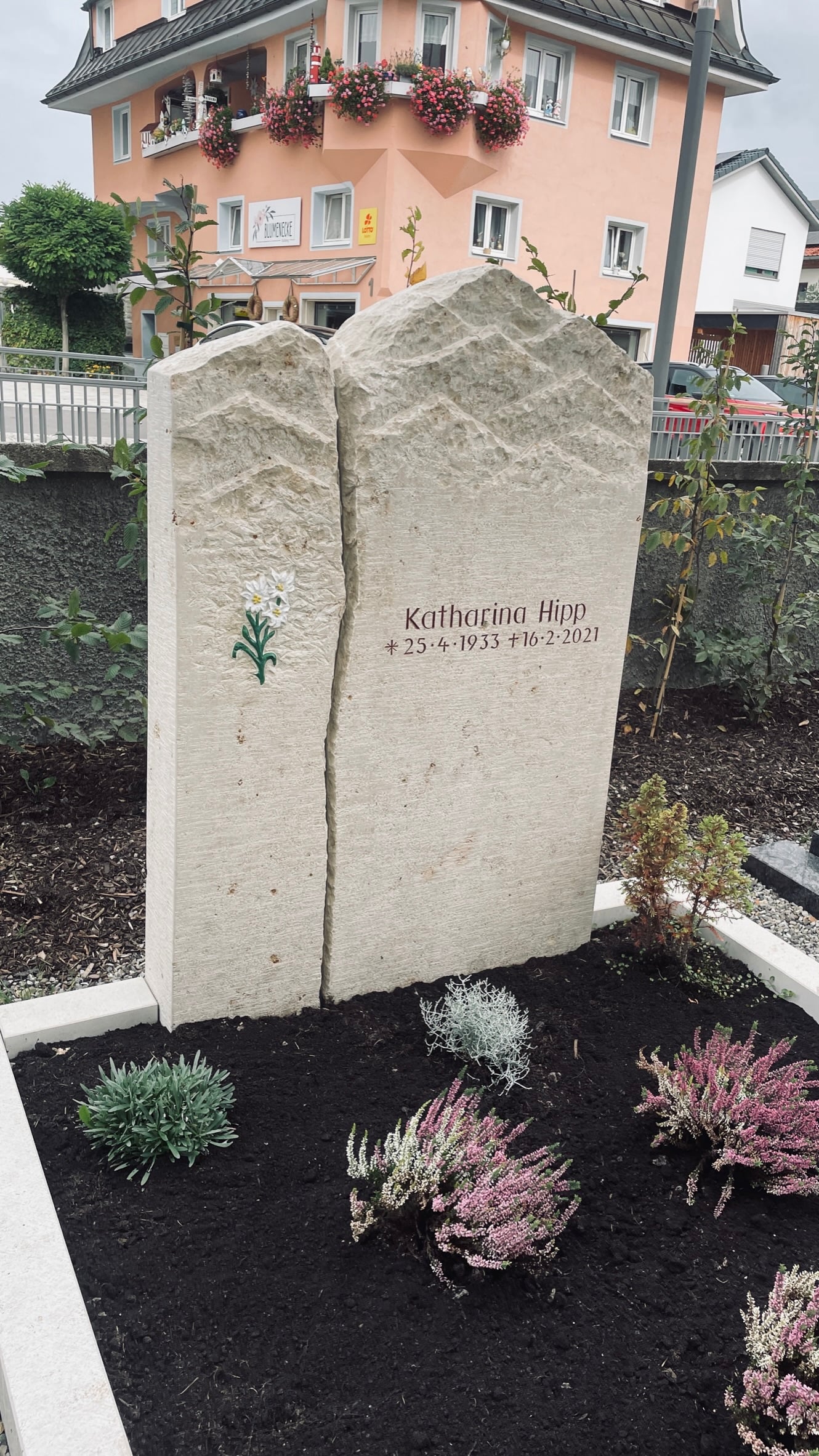 Zweiteiliger cremefarbener Kalkstein-Grabstein mit Bergpanorama-Silhouette und farbigem Enzian-Motiv
