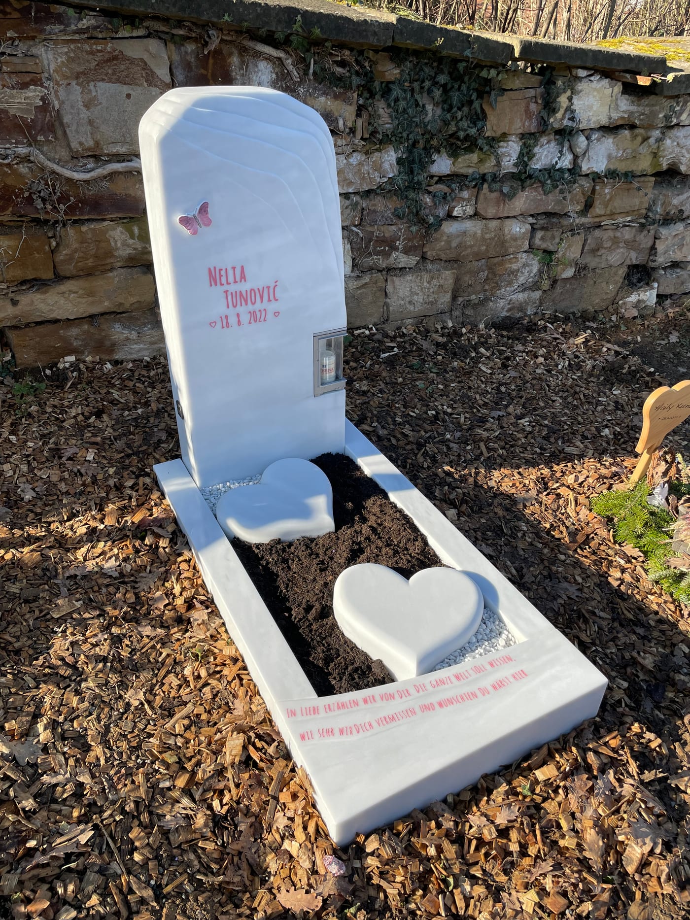 Kindergrabstein aus weißem Marmor mit aufrechter Stele, liegender Herzform und integriertem Windlicht – Ansicht 2
