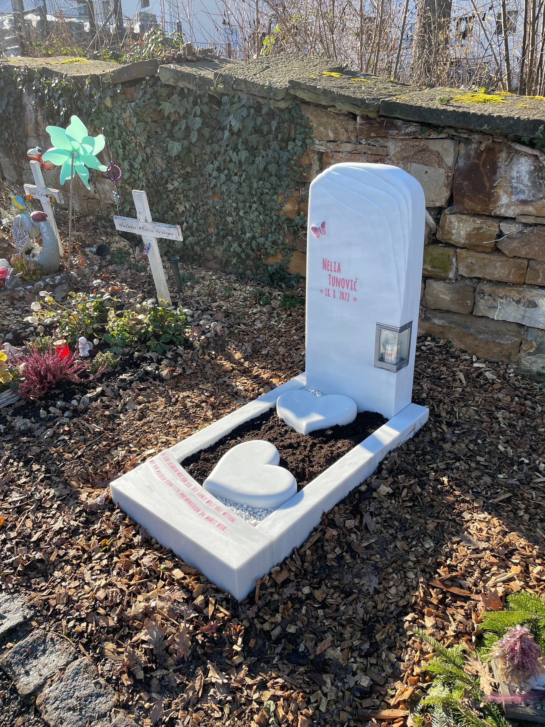 Kindergrabstein aus weißem Marmor mit aufrechter Stele, liegender Herzform und integriertem Windlicht