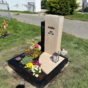 Zweiteiliger Grabstein mit heller Kalksteinstele und tiefschwarzer Hochglanz-Graniteinfassung