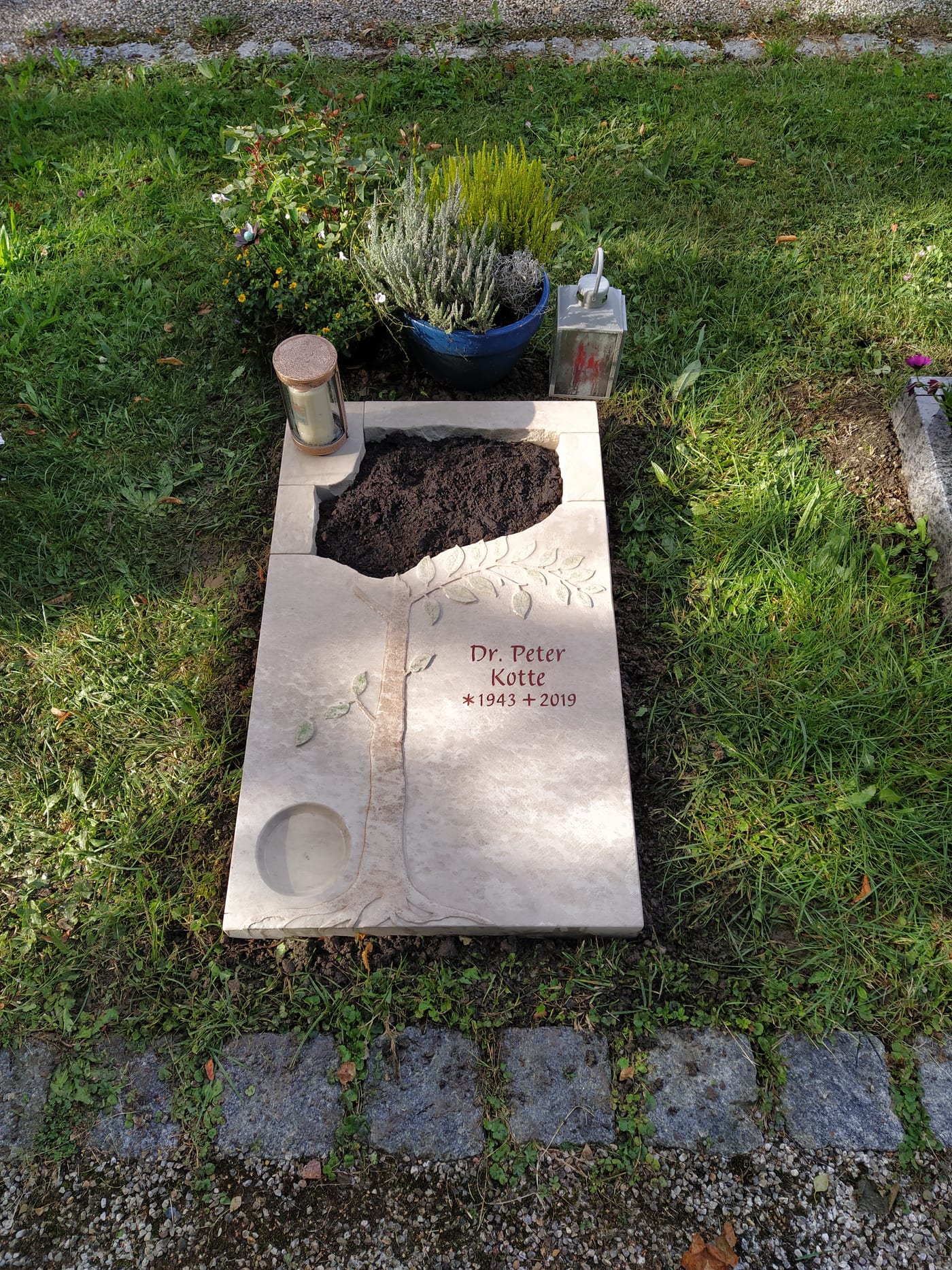 Heller Kalkstein-Liegestein für Urnengrab mit sandgestrahltem Baummotiv und integrierten Kerzenöffnungen – Ansicht 3