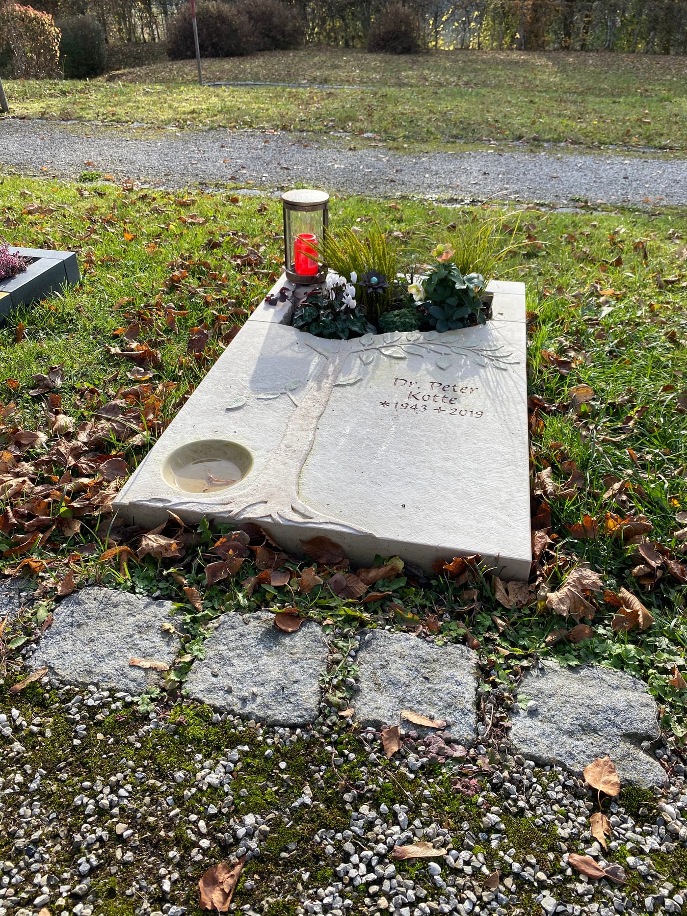 Heller Kalkstein-Liegestein für Urnengrab mit sandgestrahltem Baummotiv und integrierten Kerzenöffnungen – Ansicht 4
