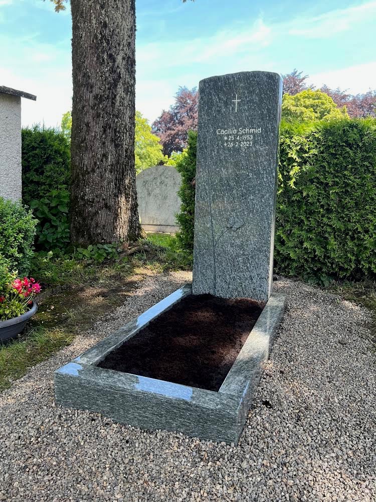 Polierter Granit-Urnengrabstein in Blau-Grau-Grün mit Kreuzgravur – handwerklich von STOI Steinmetzwerkstatt