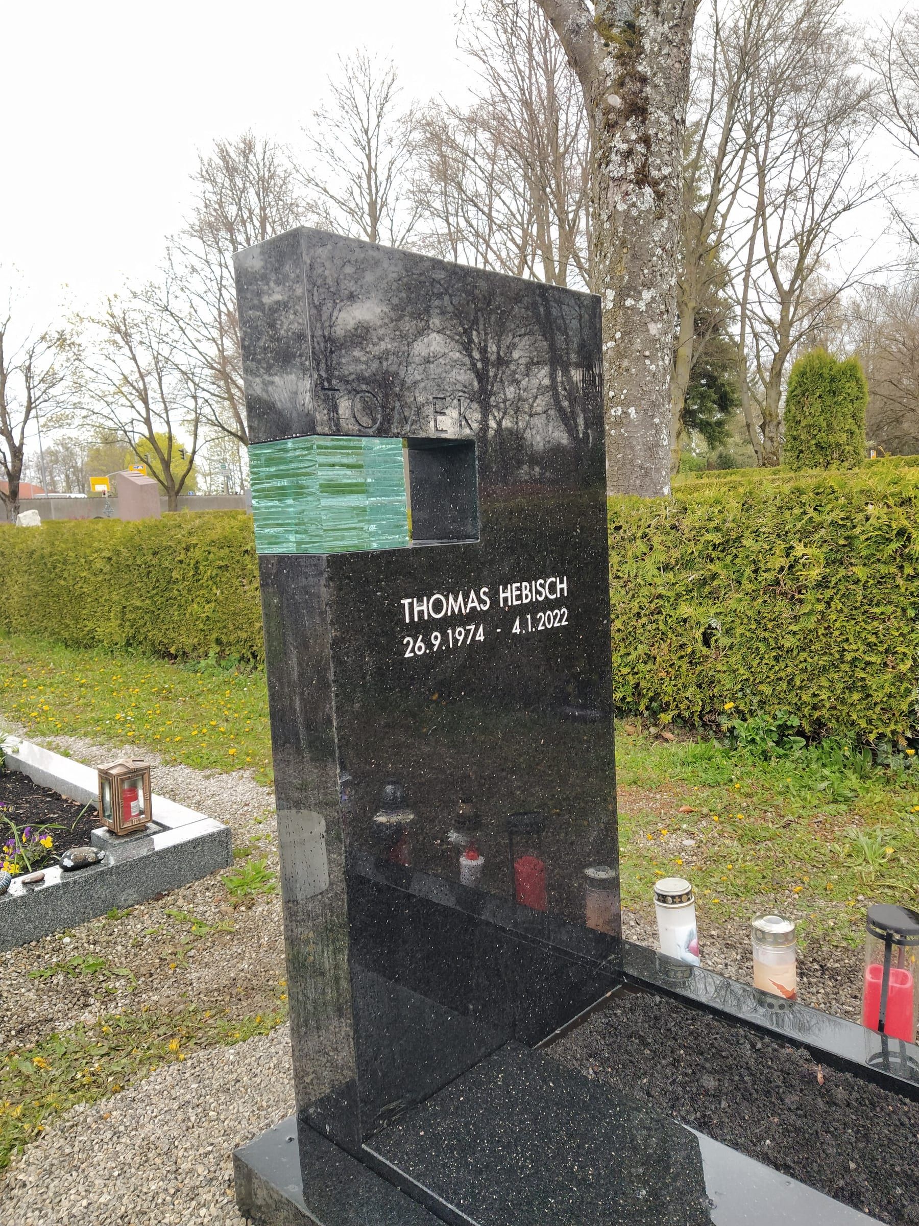 Massiver Schwarzgranit-Urnengrabstein mit integriertem grünen Glaswürfel – handwerklich von STOI Steinmetzwerkstatt