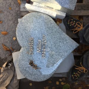 U 534 | Herzförmiger Urnengrabstein aus hellem Granit mit Bronzerose
